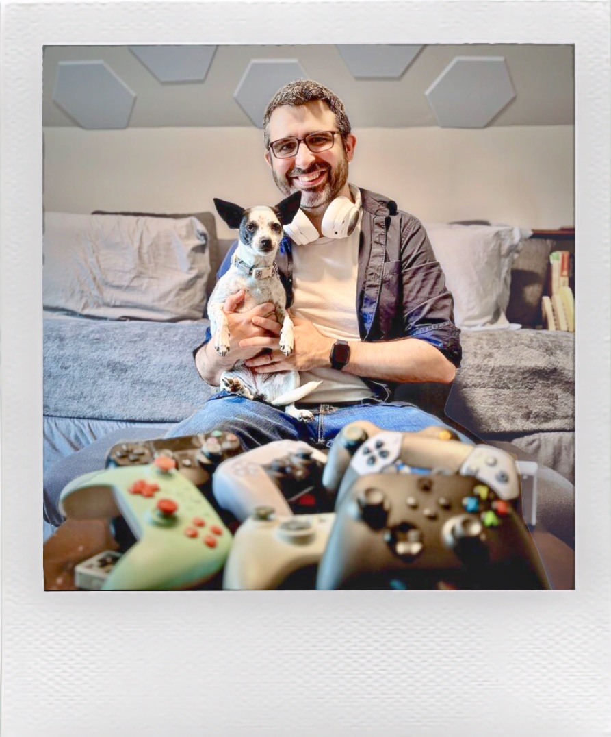 Jesse holding Magpie, with a pile of game controllers in the foreground